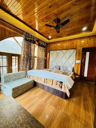 um quarto com uma cama e uma ventoinha de tecto em Frosty Mountain Resort em Pahalgam