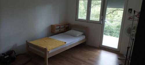 Habitación pequeña con cama y ventana en Guest House Đurmani, en Čanj