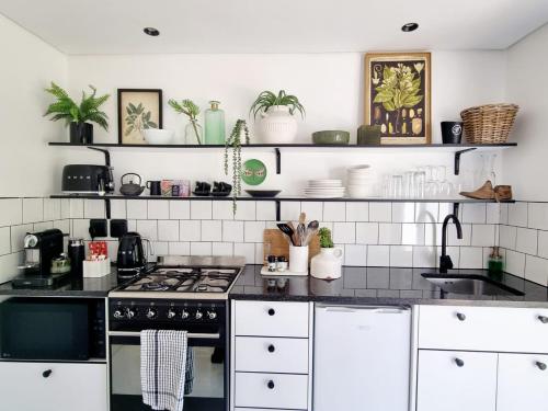 a kitchen with black counter tops and white appliances at Brenaissance Wine & Stud Estate in Stellenbosch