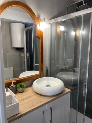 uma casa de banho com um lavatório e uma cabina de duche em vidro. em Monte y mar Albufereta em Alicante