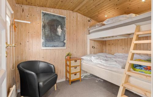 2 Bedroom Beach Front Home In Otterup في Otterup: غرفة نوم مع سرير بطابقين وكرسي