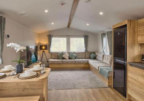 a living room with a couch and a table at Cosy Caravan New for 2024! in Newquay