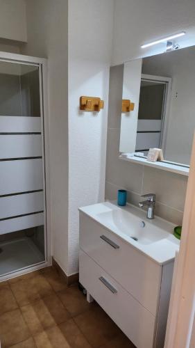 une salle de bain avec un lavabo blanc et un miroir dans l'établissement T1 bis à 50 m de la plage, à Sainte-Maxime