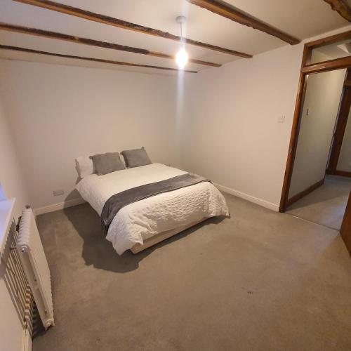 比勒瑞卡的住宿－Beautiful and Cozy 2 Bedroom Apartment Billericay，卧室位于客房的角落,配有一张床