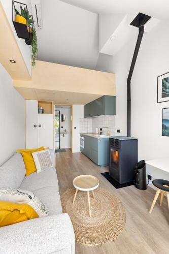 a living room with a couch and a table at Romantisch huisje met houtkachel & airco op 2,5km van zee in Groede