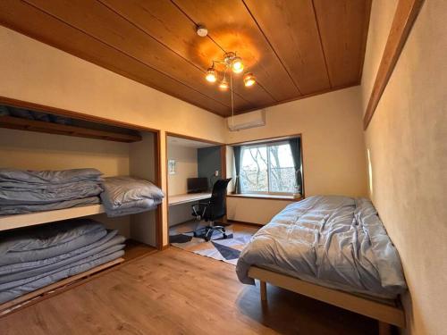 a bedroom with two bunk beds and a desk at La Assayaca Nasu in Nasu-yumoto