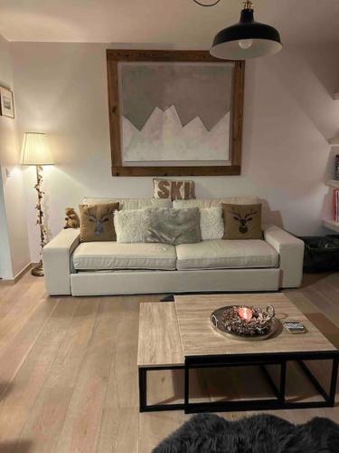 a living room with a couch and a coffee table at A 2 min. à pied du centre de Crans et des remontée in Lens