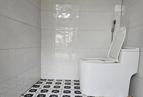 a white bathroom with a toilet with the lid up at PRIVATE LAKE House in Hanoi