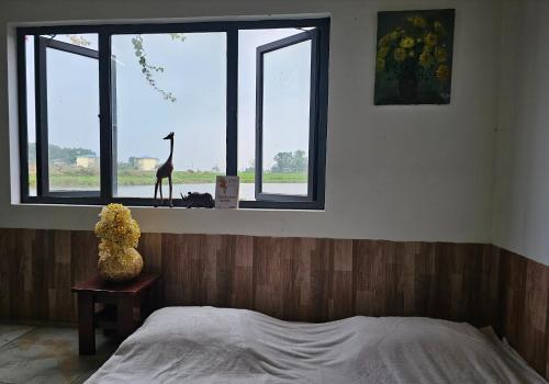 a bedroom with a bed and a giraffe in a window at PRIVATE LAKE House in Hanoi