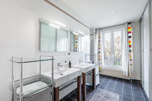 a white bathroom with two sinks and a window at Maison Familiale proche sites JO 2024 in Nanterre