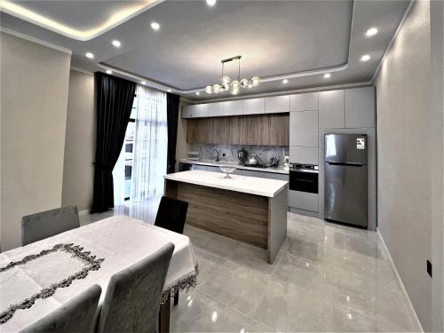 a kitchen with a table and a refrigerator at Gabala Villa Premium in Küsnǝt