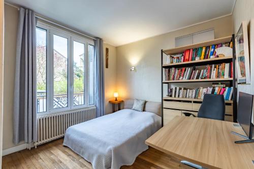 a bedroom with a bed and a book shelf at Maison Familiale proche sites JO 2024 in Nanterre