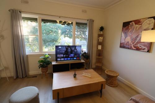 sala de estar con TV y mesa en Humble Abode near Ringwood, en Heathmont