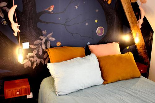a bedroom with a bed with a tree mural at Le Domaine du Château in Varennes-lès-Narcy