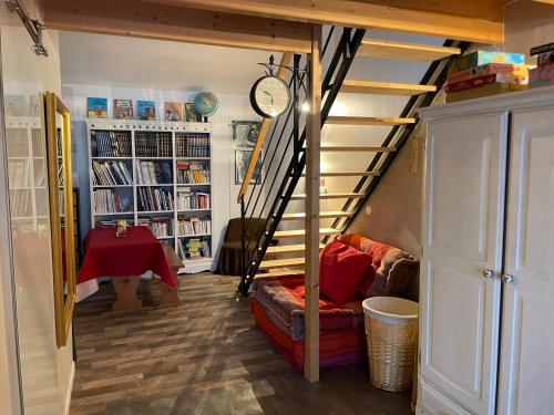 - un salon avec un escalier, un canapé et une table dans l'établissement STUDIO T, à Angoulins-sur-Mer