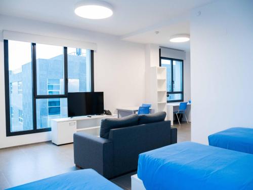 sala de estar con sofá y TV en Apartamentos Turísticos UNEATLANTICO, en Santander