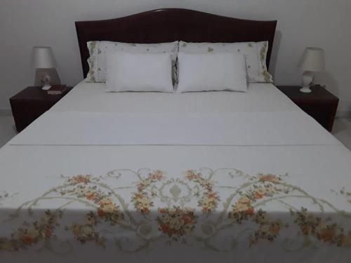 a white bed with two nightstands and two pillows at Kaza Mamai di Fora in Calheta de São Miguel