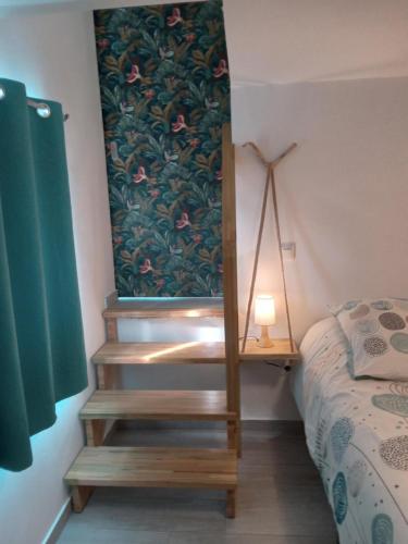 a bedroom with a staircase next to a bed at Le Jardin in Saint-Leu