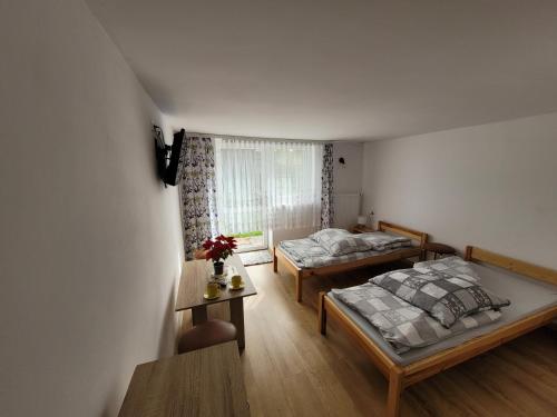 a bedroom with two beds and a window at Ogrodzieniec Pokoje 59 in Ogrodzieniec