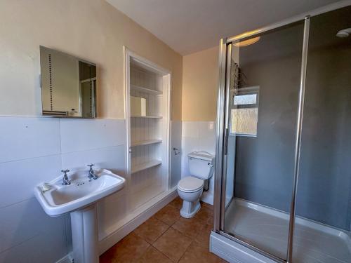 een badkamer met een toilet, een wastafel en een douche bij Abbey Farmhouse 
