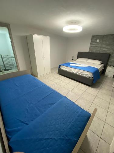Un dormitorio con una cama con una sábana azul. en Casa vacanza, en Mascali