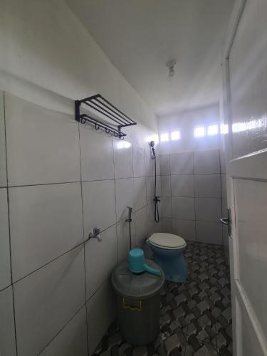 a bathroom with a toilet and a trash can at Rumah Pemandangan Lembah & Pegunungan tepi Jalan Raya in Banyumas