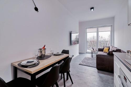 een keuken en een woonkamer met een tafel en stoelen bij Apartament Sztuk Pięknych 14 in Piła