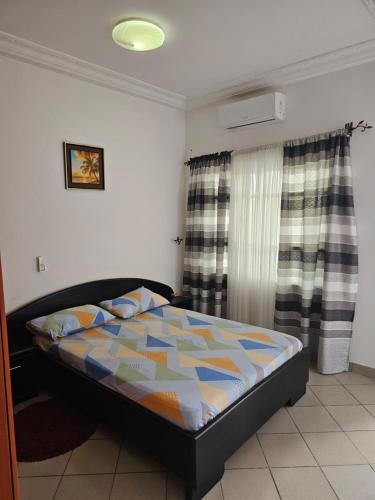 a bedroom with a bed with a colorful comforter at Appartement de luxe in Cotonou