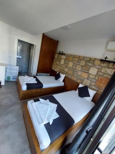 a bedroom with two beds and a stone wall at WB Weekend Otel in Bodrum City