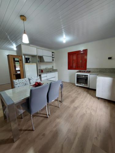 a kitchen and dining room with a table and chairs at Ap proximo ao lago in Bento Gonçalves