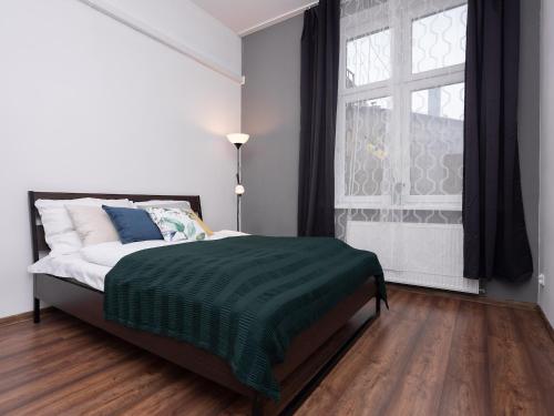 a bedroom with a bed with a green blanket and a window at Dietla 57, two-bedroom apartment with living room, apartment 24 , Ulysses in Krakow