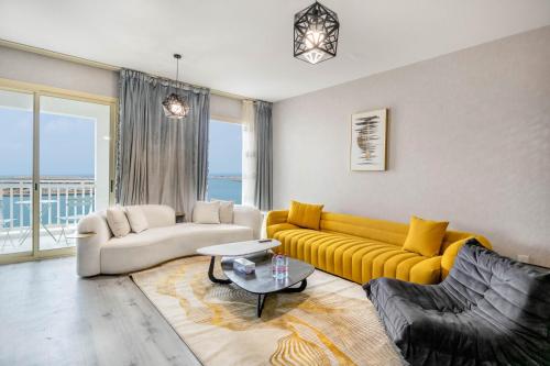 a living room with a yellow couch and a table at Water surrounded beautiful 2BR apartment in Ras al Khaimah