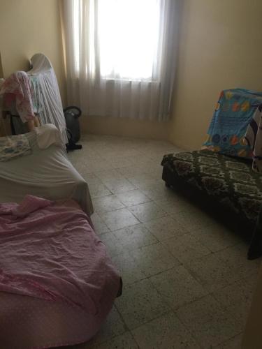 sala de estar con 2 camas y ventana en Mersin Erdemli Aykent Sahil Sitesi, en Mersin