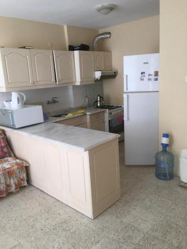 a kitchen with white cabinets and a white refrigerator at Mersin Erdemli Aykent Sahil Sitesi in Mersin