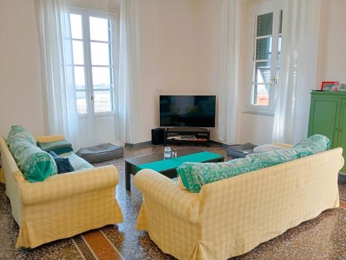 ein Wohnzimmer mit 2 Sofas und einem TV in der Unterkunft I MUSETTI in Genua
