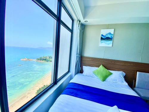 a bedroom with a bed and a window with a beach at Ocean Dream Apartment Nha Trang in Nha Trang