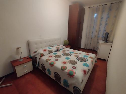 ein Schlafzimmer mit einem Bett mit einer Blumendecke in der Unterkunft Le Comari in Mailand