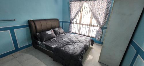 a bedroom with a bed in front of a window at Humayyah Homestay in Sungai Besar