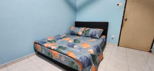 Bett in einem Zimmer mit blauer Wand in der Unterkunft Humayyah Homestay in Sungai Besar