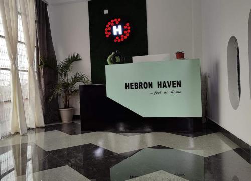 un cartel sentado en un piso en una habitación en Hebron Haven, en Jaigaon