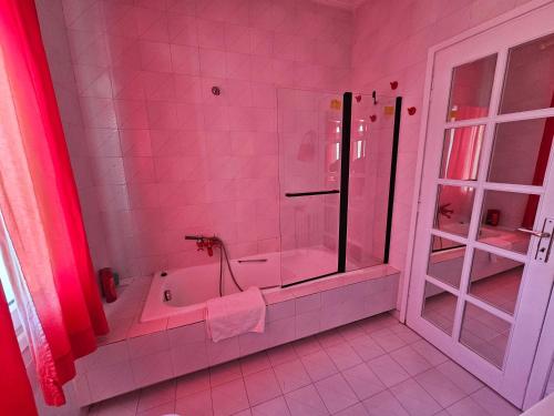 uma casa de banho rosa com uma banheira e um chuveiro em Villa Emily em Lagonissi