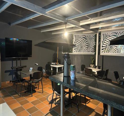 ネイバにあるHOTEL CASA LUKEのテーブルと椅子、薄型テレビが備わる客室です。