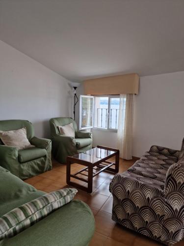uma sala de estar com um sofá e uma mesa de centro em Apartamento Vistas Olas del Mar & Playa Raxó em Raxó