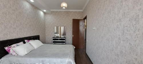 a bedroom with a bed and a mirror on the wall at Apartment in Tbilisi near Didube metro station in Tbilisi City