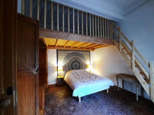 sypialnia z łóżkiem i klatką schodową w obiekcie Le Lotus en Lubéron- appartement 50m² + terrasse w Apt