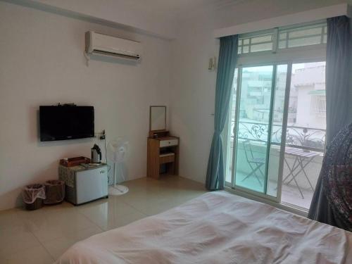 1 dormitorio con 1 cama y puerta corredera de cristal en 薇琪小屋, en Hualien City