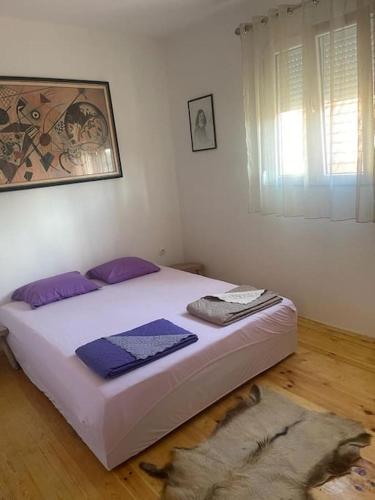 Un dormitorio con una cama con almohadas moradas. en Kadmi en Njeguši