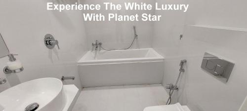 a white bathroom with a toilet and a sink at Planet Star Homestay in Bikaner