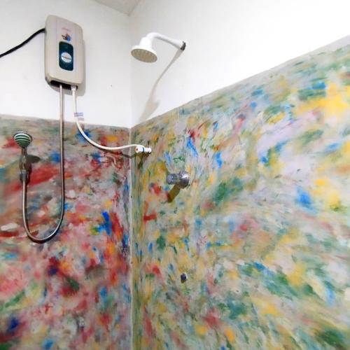 y baño con ducha y una pintura en la pared. en Villa lovely birds mirissa, en Mirissa