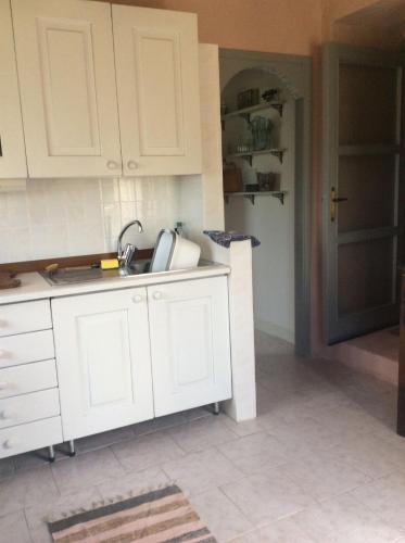 a kitchen with white cabinets and a sink at Cozy Cottage Retreat in Bajardo in Baiardo